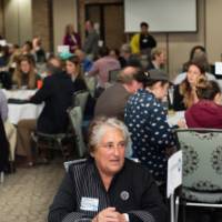 Three women engage in civil discourse at a round table discussion.